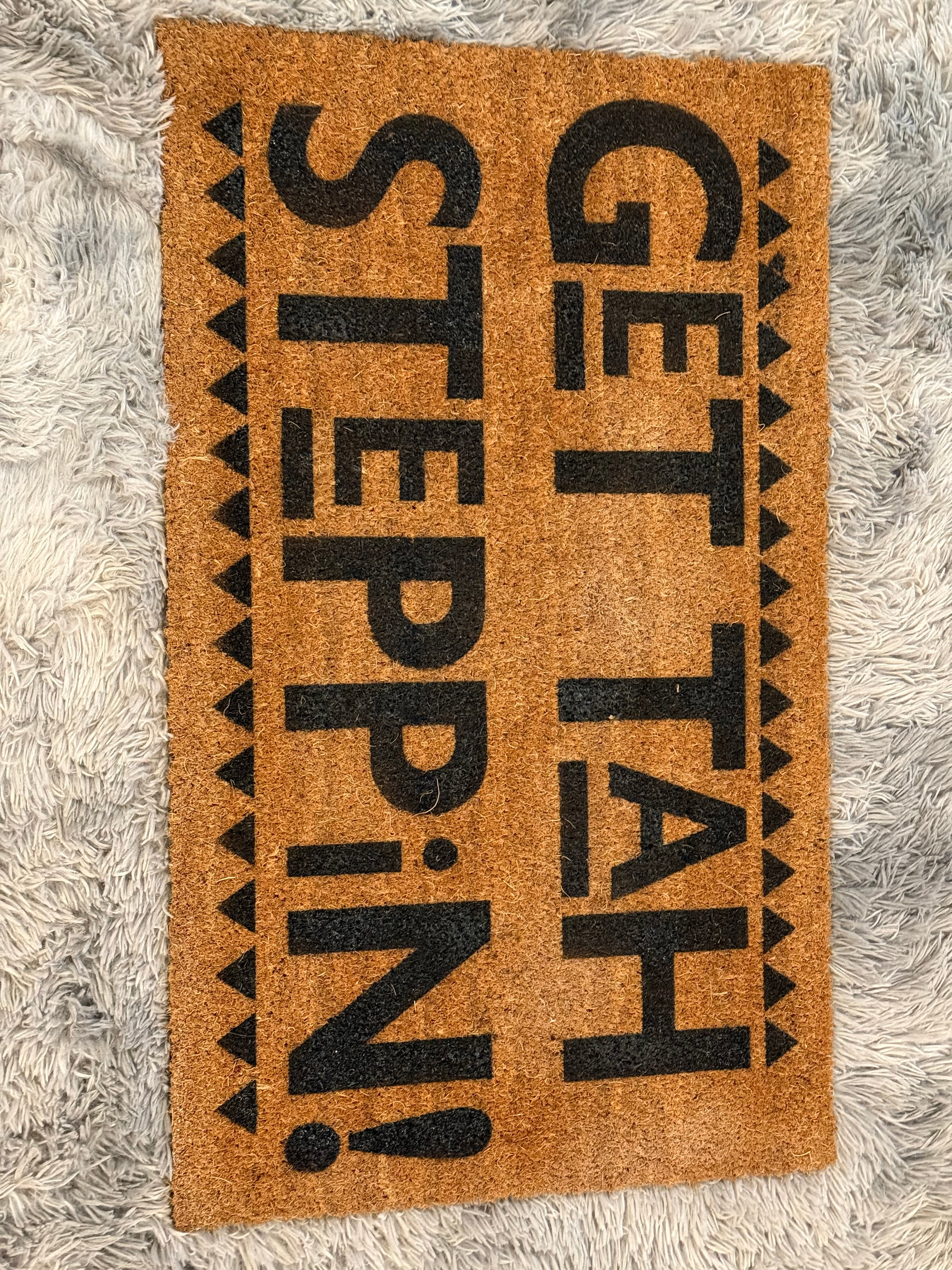 Doormat with text 'GET TAH STEPPIN!' on a textured surface